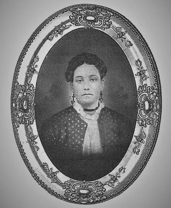 A black and white photo of a woman in an ornate frame.