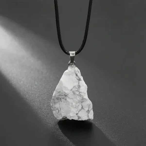 White stone pendant on black cord necklace.