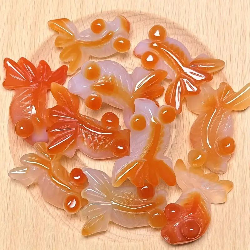 Orange and white carved agate fish charms.