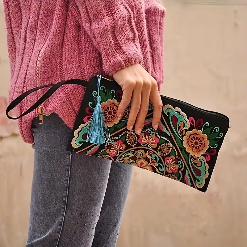 Woman holding a floral embroidered clutch.