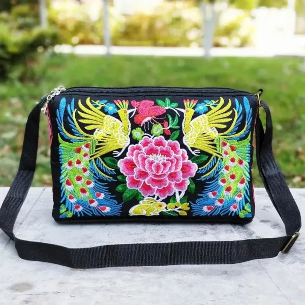 Black embroidered purse with peacocks and flowers.