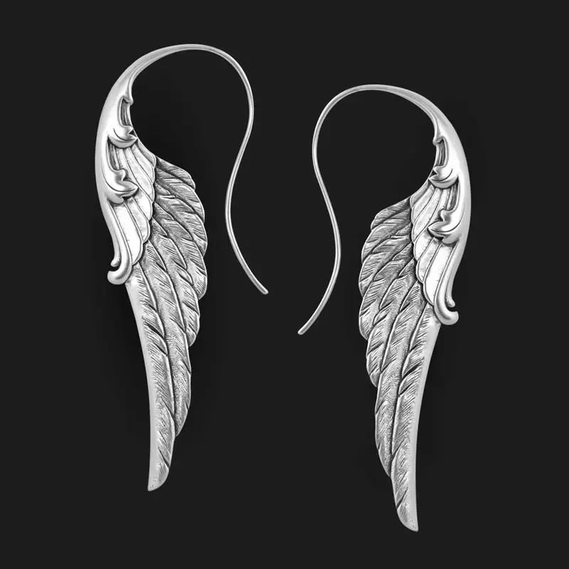 Silver angel wing earrings on black background.