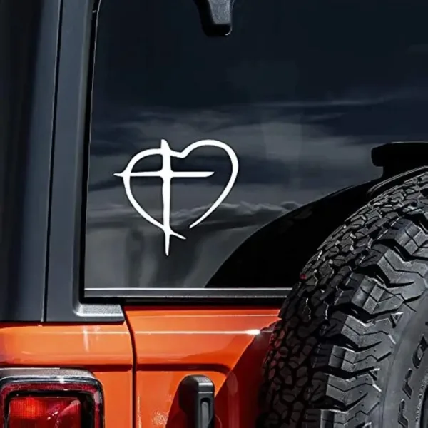 Cross inside a heart on car window.