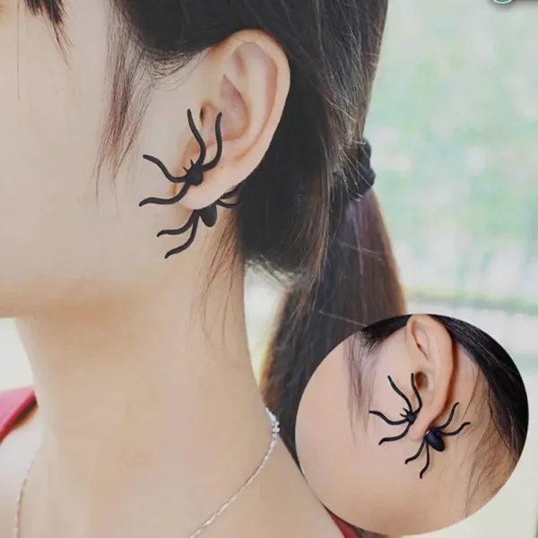 Woman wearing black spider earrings.