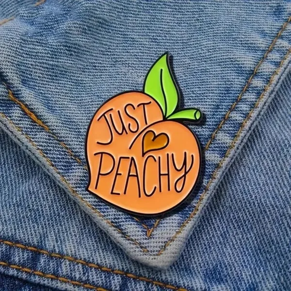 Peach-shaped pin saying "Just Peachy"