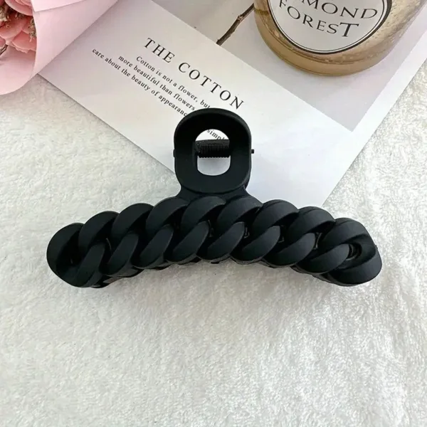 Black chain hair clip on white background.