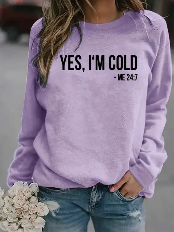 Woman wearing a purple sweatshirt that says "Yes, I'm cold."