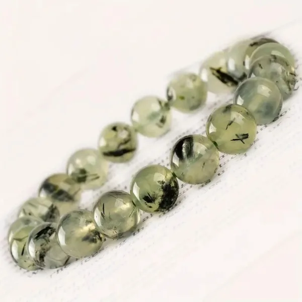 Green gemstone bracelet with black inclusions.