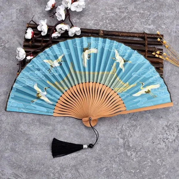 Blue hand fan with crane design.