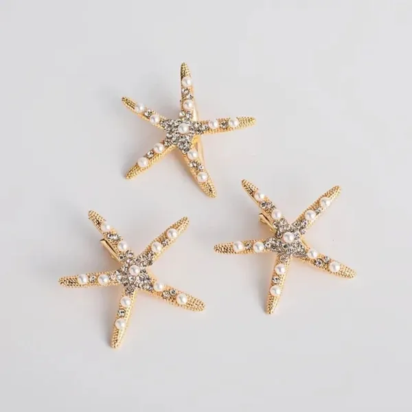 Three gold starfish hair clips with pearls.