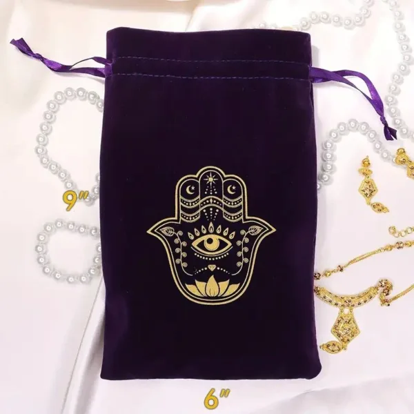 Purple velvet bag with gold hamsa hand design.