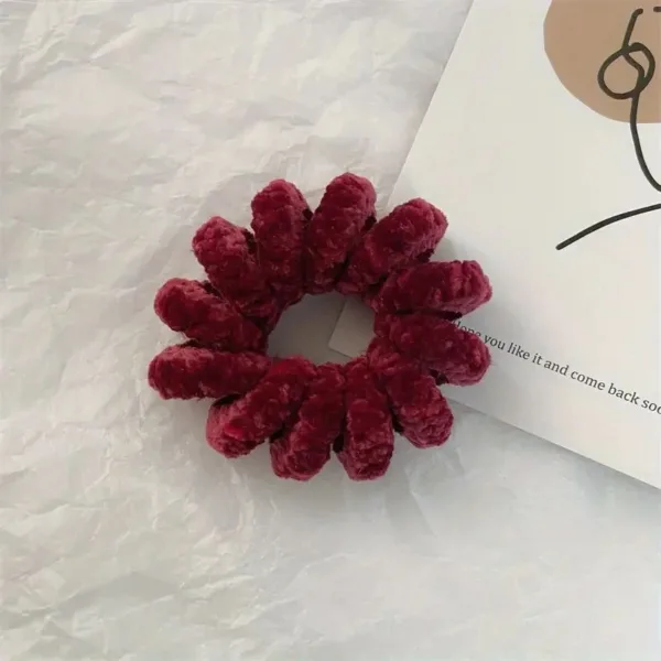 Red fuzzy hair scrunchie on white background.