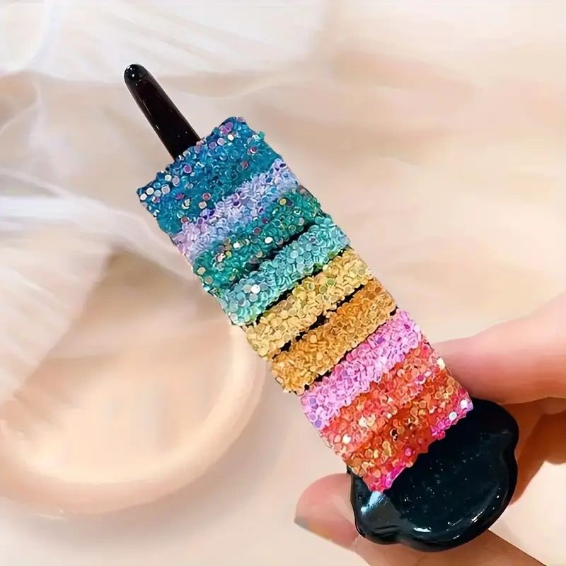 Rainbow glitter hair clip on hand.