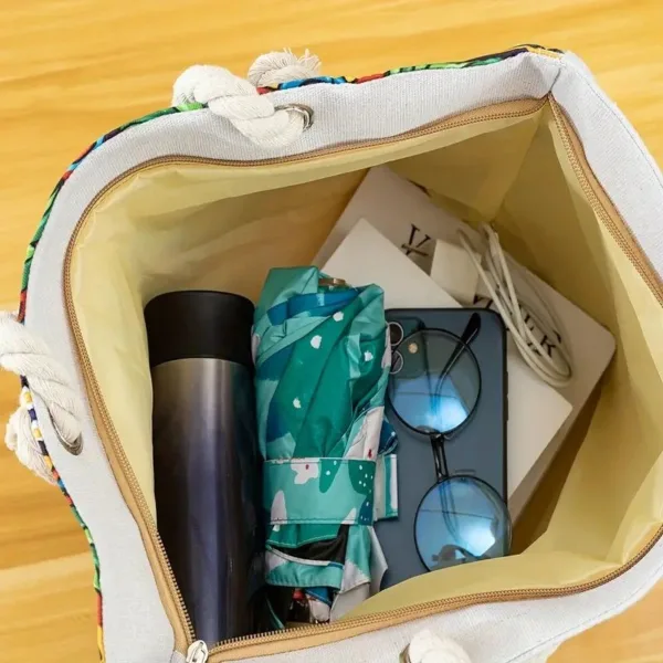 Canvas tote bag with sunglasses, umbrella, and water bottle.