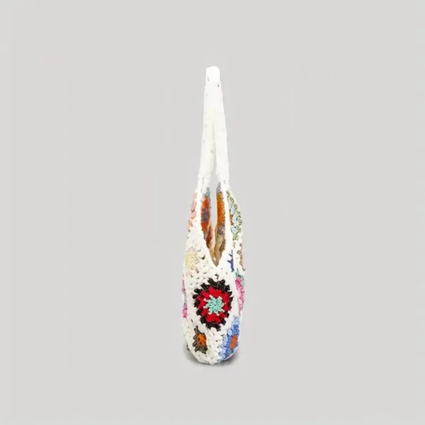 White crocheted bag with colorful flowers.