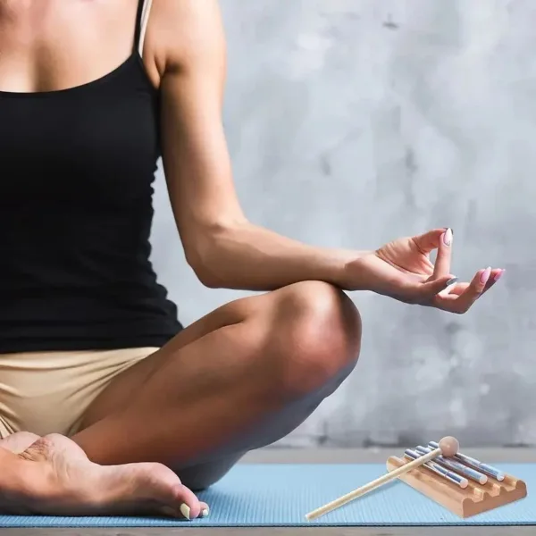 Woman meditating with a tuning fork.