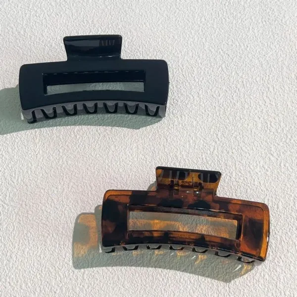 Two plastic hair clips, black and brown.