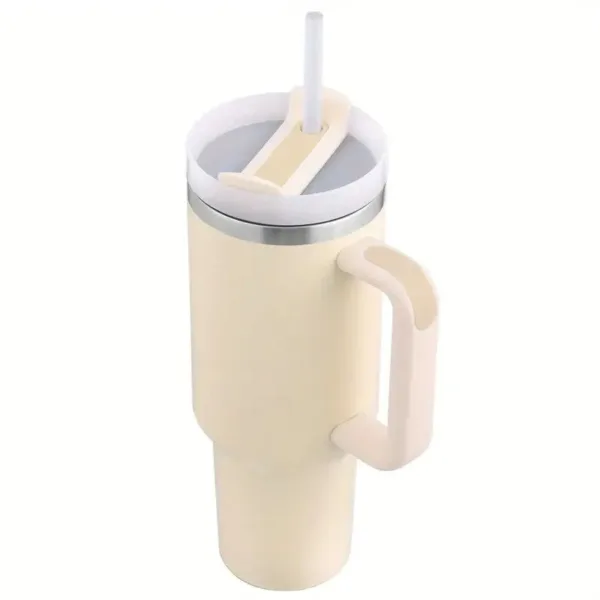 Cream travel mug with straw and handle.