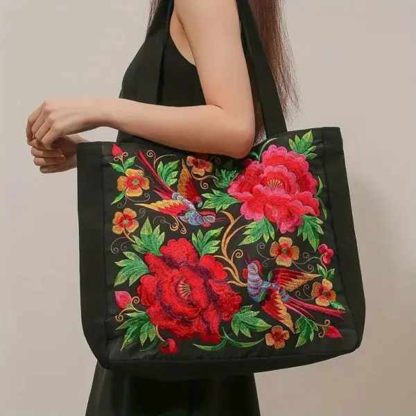 Black tote bag with floral embroidery.