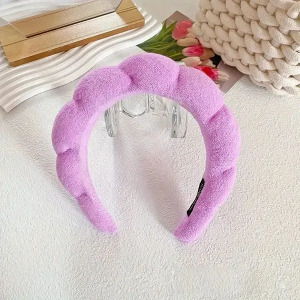 Purple padded headband for hair.