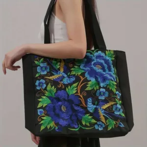 Black tote bag with floral embroidery.