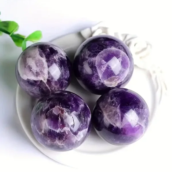 Four purple amethyst crystal spheres on a plate.