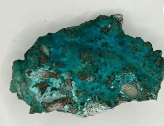 Rough turquoise gemstone with brown veins.