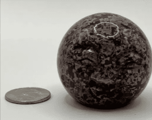 Gray and black speckled stone sphere.