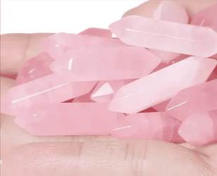 Hand holding a pile of pink crystals.