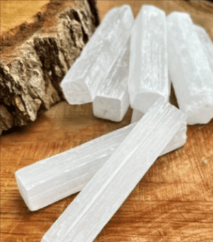 White selenite crystal sticks on wood.