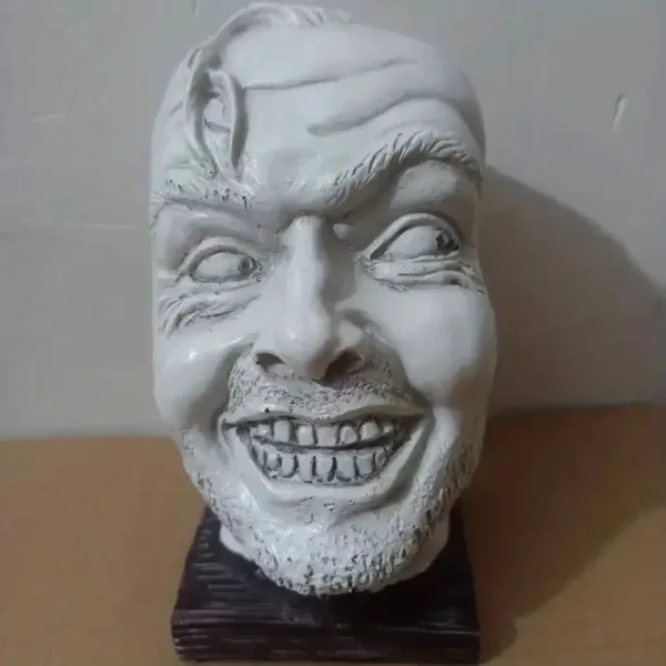 White ceramic sculpture of a grinning man.