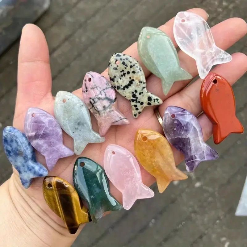 Carved gemstone fish pendants on hand.