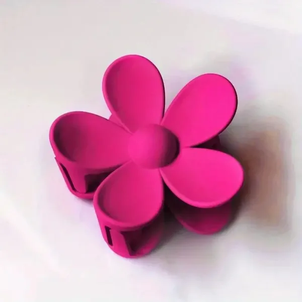 Pink flower hair clip on white background.