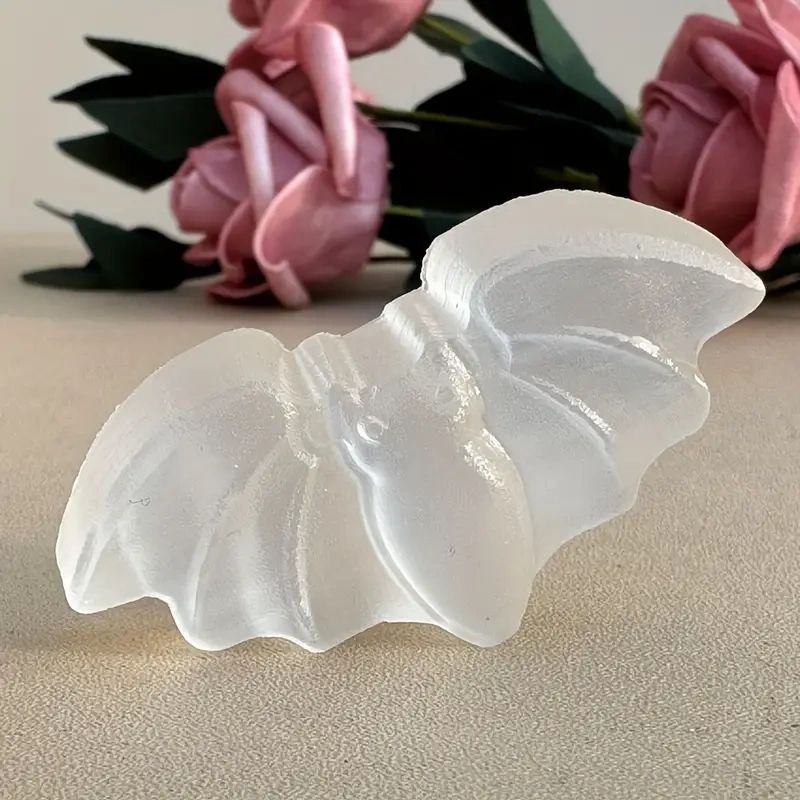 White glass bat figurine on table.