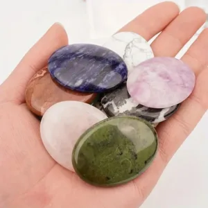 Hand holding colorful gemstone palm stones.