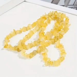 Yellow gemstone chip necklace on white background.