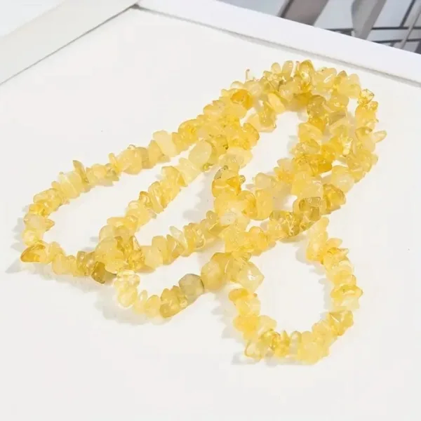 Yellow gemstone chip necklace on white background.