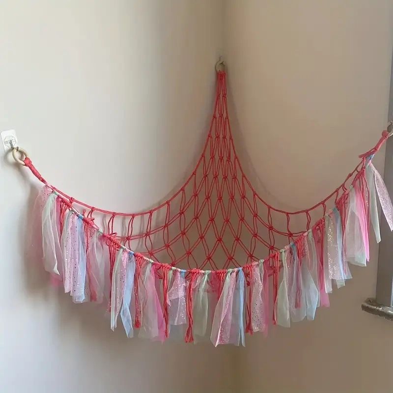 Pink and white macrame hammock hanging in corner.