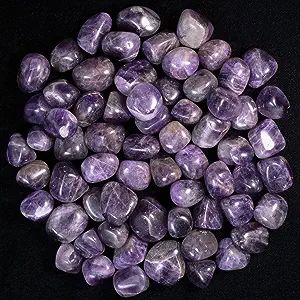 Purple tumbled amethyst stones on black background.