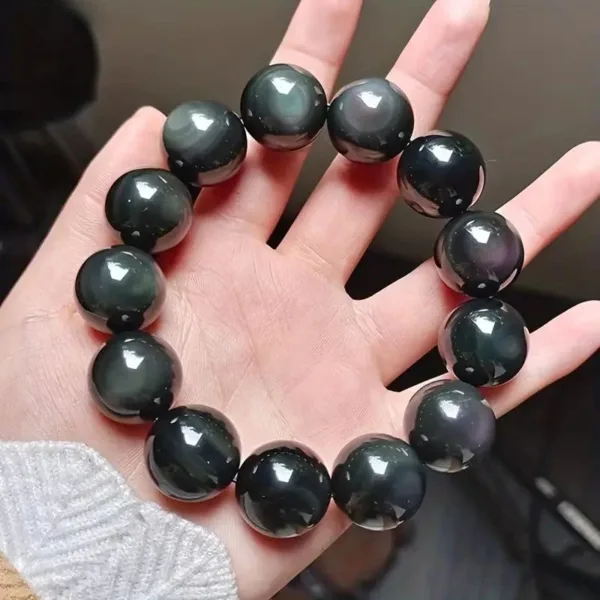 Black obsidian bead bracelet on hand.