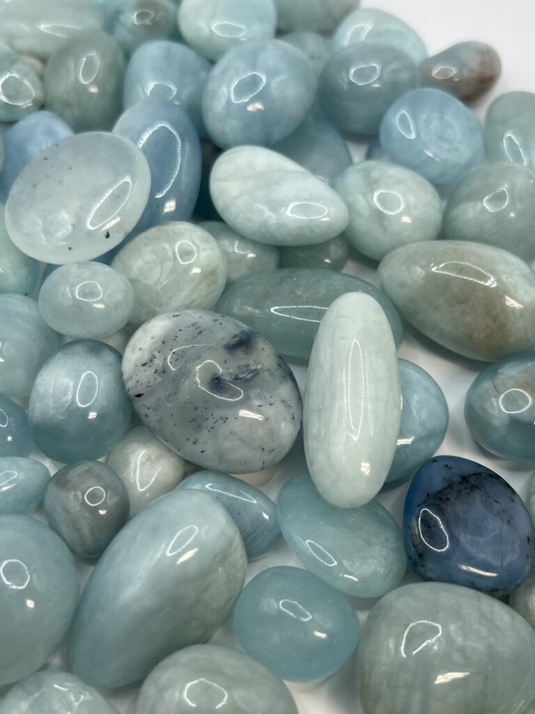 Aquamarine tumbled stones, light blue.