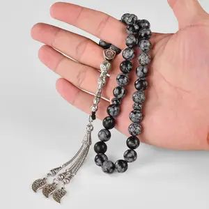 Black and white prayer beads in hand.