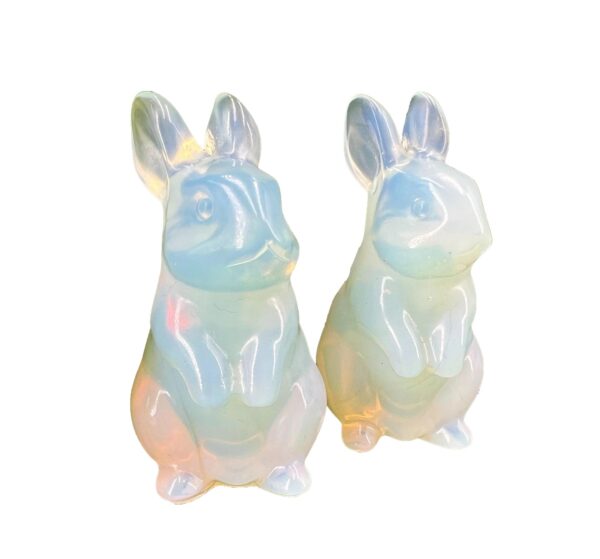 Two iridescent opal bunny figurines.