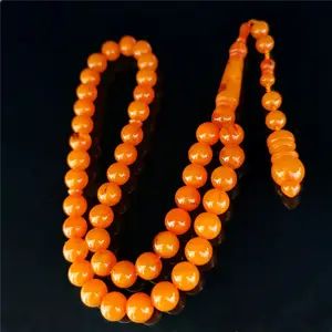 Orange amber prayer beads on black background.