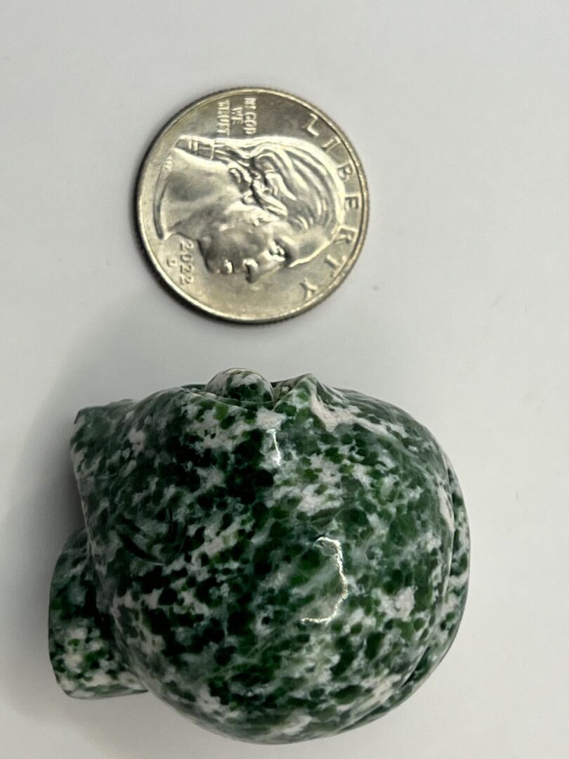 Green and white carved stone skull.