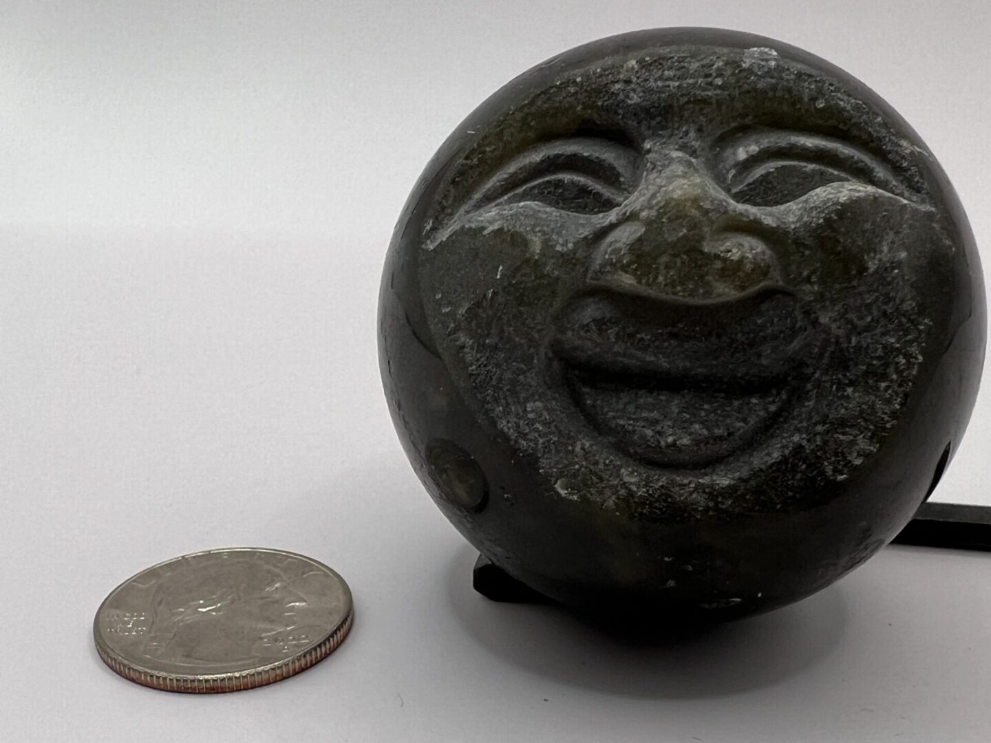 Stone sculpture of a smiling face.