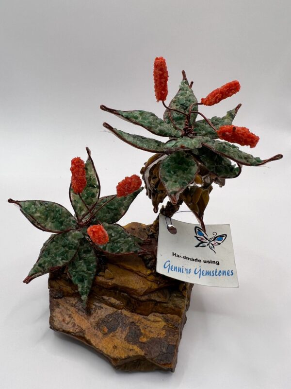 Gemstone flower sculpture on rock base.