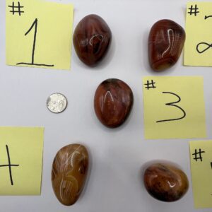 Five numbered agate stones on a white surface.