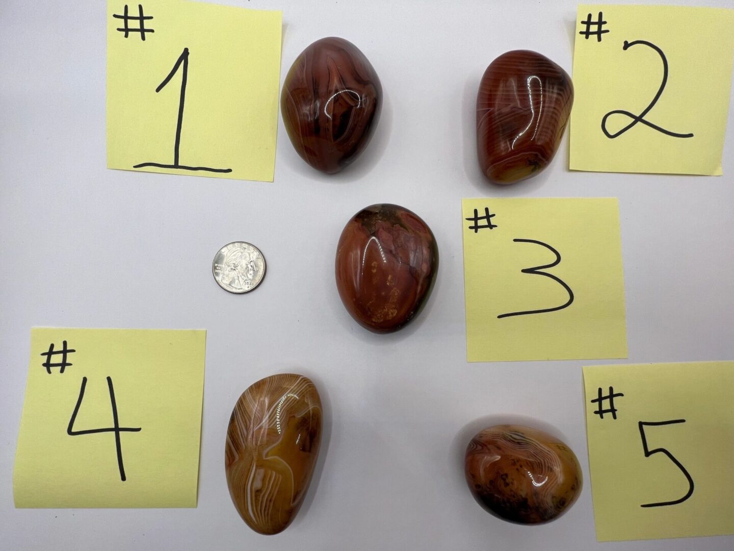 Five numbered agate stones on a white surface.