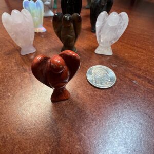 Carved stone angel figurines on wood table.